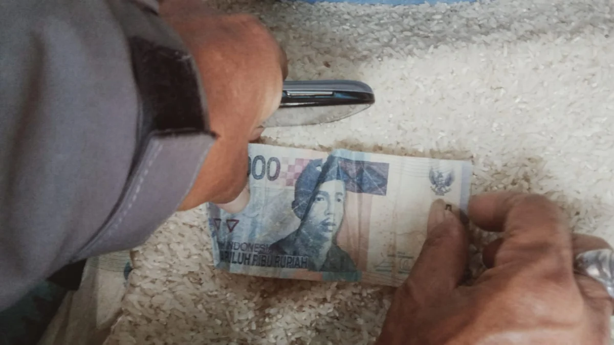 Pedagang beras di Pasar Guntur Ciawitali menunjukkan uang palsu