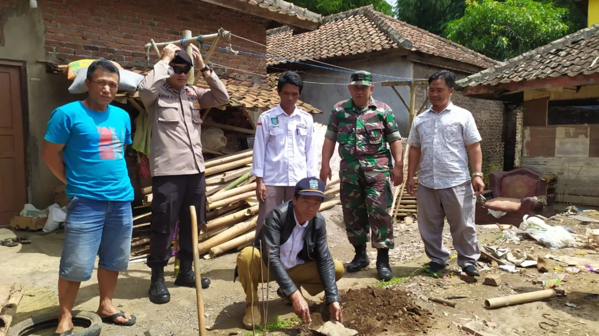 Kades Sukasenang melakukan peletakan batu pertama pembangunan rumah Enung