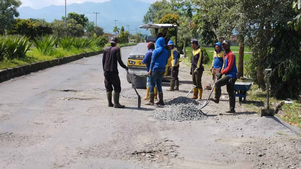 Pekerja dari Dinas PUPR Garut sedang memperbaiki jalan rusak di Jl. KH. Anwar Musaddad, Selasa 11 April 2023.