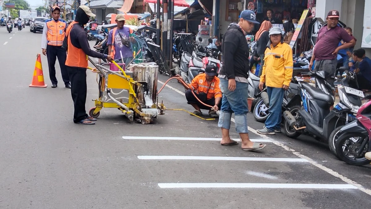 Petugas Dishub Garut sedang menandai marka jalan Ahmad Yani, yang akan dijadikan tempat parkir.*