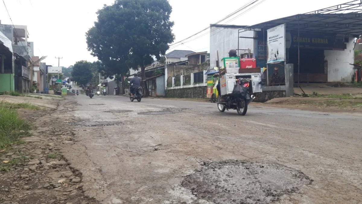 Jalan berlubang di Gatot Subroto ditambal oleh warga, Minggu 17 Maret 2024.